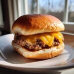 Close-up of a juicy hamburger with melted cheddar cheese, ready to eat after cooking a hamburger using an air fryer.