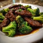 Close-up of tender slices of Chinese Beef And Broccoli coated in savory brown sauce.