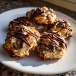 Close-up of five freshly baked Florentines cookies drizzled with dark chocolate on a white plate.
