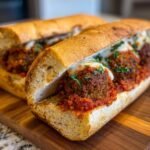 Close-up of two Homemade Vegan Chickpea Quinoa Meatball Subs filled with meatballs, marinara sauce, and melted vegan cheese.
