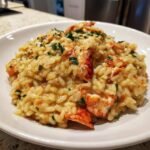 Close-up of a serving of rich and creamy lobster risotto topped with fresh parsley.