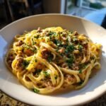 A close-up of creamy Garlic Butter Sausage Pasta tossed with crumbled sausage and topped with fresh parsley.