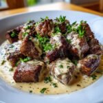 Close-up of juicy Garlic Butter Steak Bites covered in Parmesan cream sauce and sprinkled with fresh parsley.