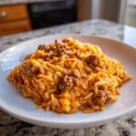 A close-up of a white plate filled with creamy Ground Beef Orzo With Tomato Cream Sauce.