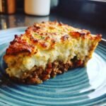 A thick slice of Ground Turkey Shepherds Pie with a golden, crispy mashed potato topping.