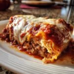 Close-up of a single Zucchini Lasagna Roll Ups serving covered in rich meat sauce and melted mozzarella cheese.
